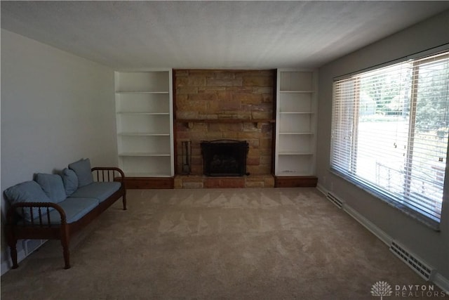 10520 Grand Vista Dr, Dayton, OH 45458 - unfurnished living room with carpet floors, built in features, a stone fireplace, and baseboards