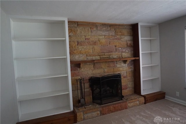 10520 Grand Vista Dr, Dayton, OH 45458 - unfurnished living room featuring a stone fireplace, a textured ceiling, carpet, baseboards, and built in shelves