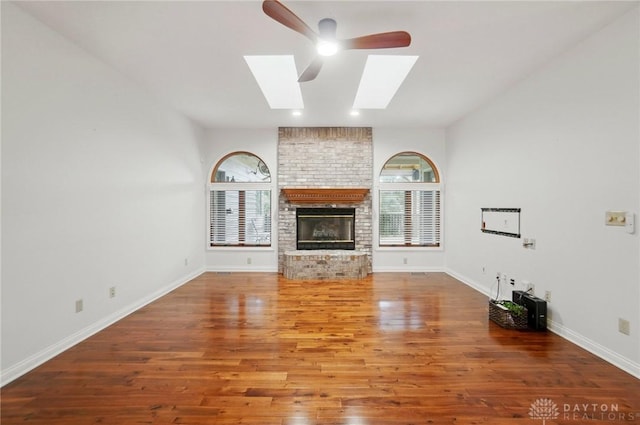 220 Fivepines Ct, Englewood, OH 45315 - unfurnished living room with a skylight, a fireplace, ceiling fan, wood finished floors, and baseboards