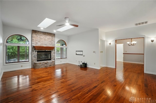 220 Fivepines Ct, Englewood, OH 45315 - unfurnished living room featuring a skylight, a chandelier, hardwood / wood-style flooring, and a brick fireplace