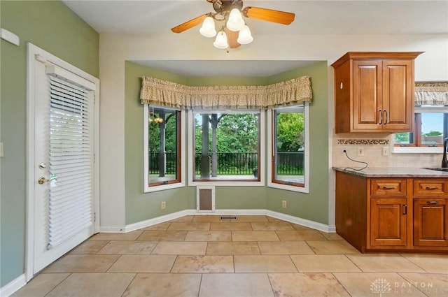 220 Fivepines Ct, Englewood, OH 45315 - kitchen with brown cabinetry, plenty of natural light, and ceiling fan