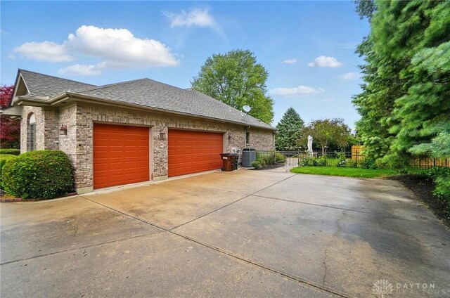220 Fivepines Ct, Englewood, OH 45315 - view of home's exterior featuring driveway, a garage, brick siding, and roof with shingles