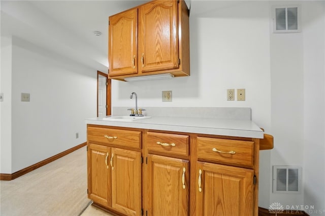 220 Fivepines Ct, Englewood, OH 45315 - kitchen with a sink, light countertops, light colored carpet, and baseboards