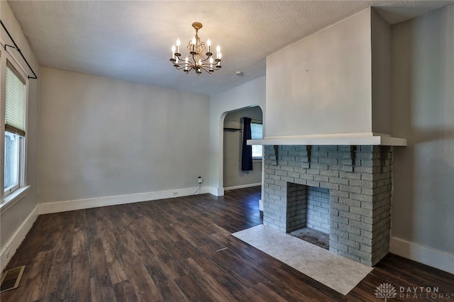 27 S Quentin Ave, Dayton, OH 45403 - unfurnished living room featuring arched walkways, plenty of natural light, a chandelier, and a brick fireplace