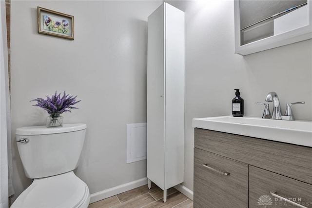 5695 E Coach Dr Unit E, Kettering, OH 45440 - bathroom with toilet, vanity, baseboards, and wood finished floors