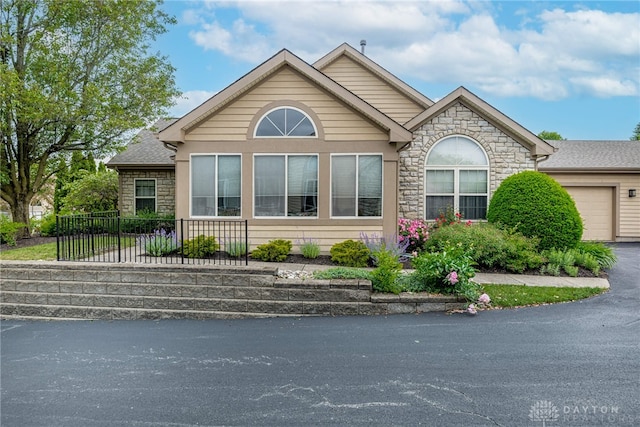91 Villa Pointe Dr, Springboro, OH 45066 - view of side of property featuring stone siding, an attached garage, and asphalt driveway