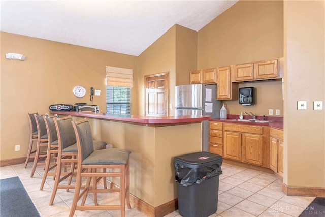 91 Villa Pointe Dr, Springboro, OH 45066 - kitchen with a sink, high vaulted ceiling, light tile patterned floors, a breakfast bar area, and baseboards