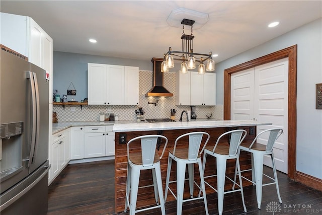 25 La Belle St, Dayton, OH 45403 - kitchen with stainless steel fridge with ice dispenser, wall chimney exhaust hood, dark wood finished floors, tasteful backsplash, and a kitchen bar