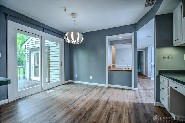 222 Walnut Grove Dr, Centerville, OH 45458 - unfurnished dining area with wood finished floors, baseboards, and a chandelier