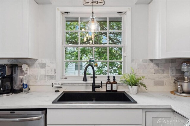 2242 Turnbull Rd, Beavercreek, OH 45431 - kitchen with a sink, dishwasher, white cabinetry, and decorative backsplash