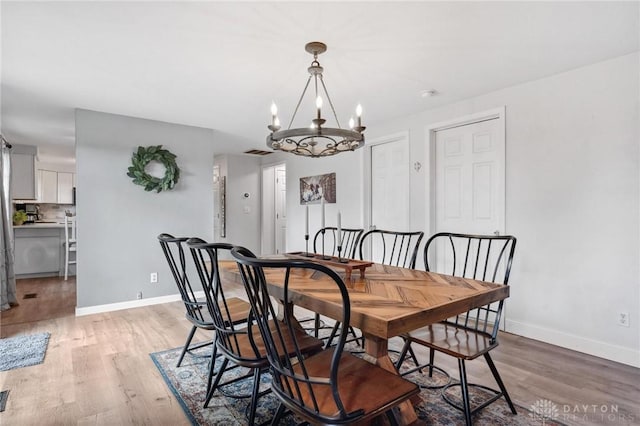 2242 Turnbull Rd, Beavercreek, OH 45431 - dining space featuring light wood-style flooring, baseboards, and a chandelier
