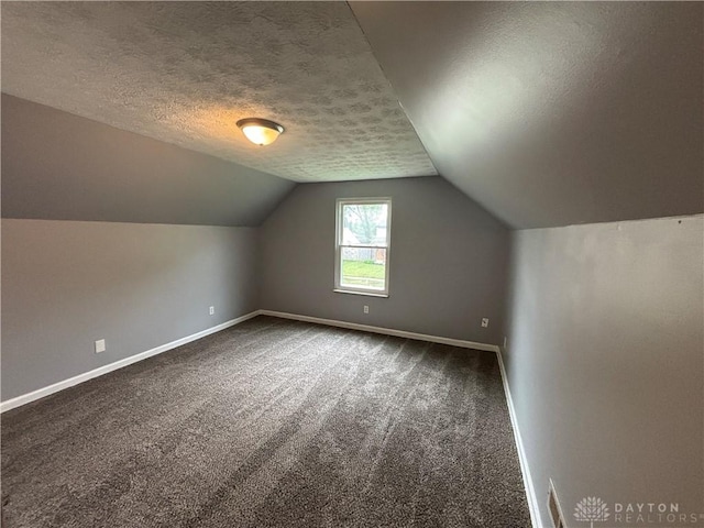 5901 Timbergate Trl, Dayton, OH 45424 - additional living space with dark colored carpet, baseboards, lofted ceiling, and a textured ceiling