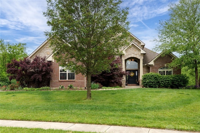 10067 Yearling Run, Dayton, OH 45458 - obstructed view of property featuring stone siding, a front yard, and brick siding