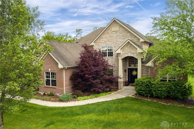 10067 Yearling Run, Dayton, OH 45458 - view of front facade with stone siding, a front yard, roof with shingles, and brick siding