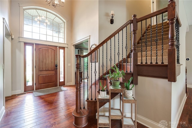 10067 Yearling Run, Dayton, OH 45458 - entryway featuring wood-type flooring, a towering ceiling, a chandelier, baseboards, and stairs