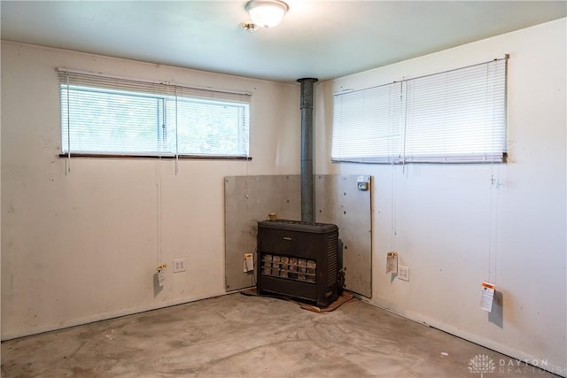 5501 Harshmanville Rd, Dayton, OH 45424 - empty room with unfinished concrete flooring and a wood stove