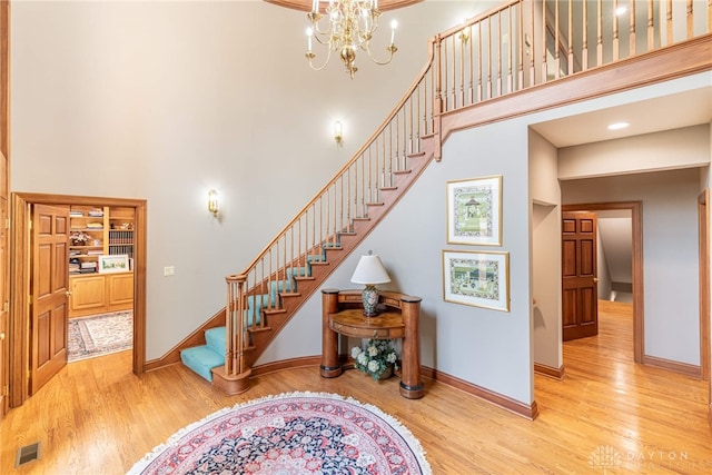 514 Shambord Cir, Kettering, OH 45429 - stairway with a towering ceiling, wood finished floors, baseboards, and a chandelier
