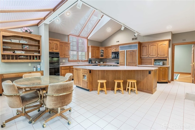 514 Shambord Cir, Kettering, OH 45429 - kitchen with black appliances, lofted ceiling, light countertops, a kitchen breakfast bar, and a kitchen island