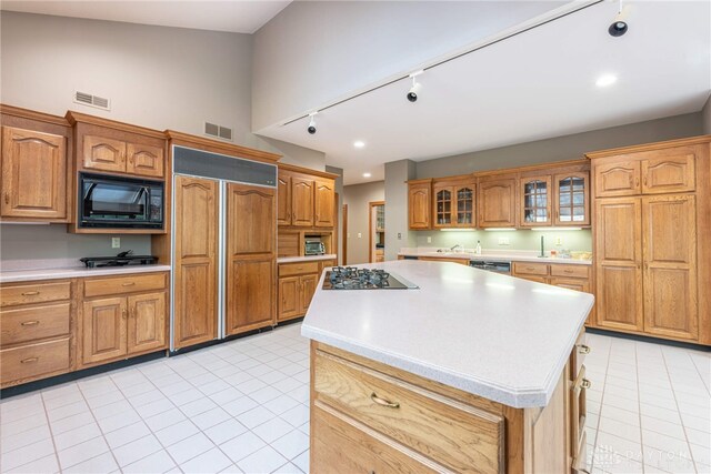 514 Shambord Cir, Kettering, OH 45429 - kitchen featuring black appliances, track lighting, light countertops, light tile patterned flooring, and glass insert cabinets
