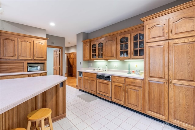 514 Shambord Cir, Kettering, OH 45429 - kitchen featuring dishwasher, light countertops, glass insert cabinets, a sink, and light tile patterned flooring