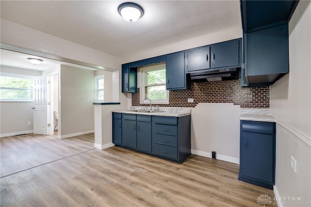 1533 Weaver St, Dayton, OH 45417 - kitchen featuring a sink, under cabinet range hood, blue cabinets, tasteful backsplash, and light countertops