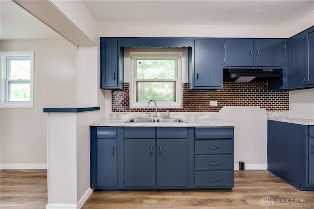 1533 Weaver St, Dayton, OH 45417 - kitchen featuring a sink, under cabinet range hood, blue cabinetry, light wood-type flooring, and light countertops
