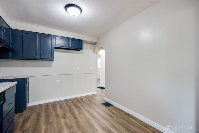 1533 Weaver St, Dayton, OH 45417 - kitchen with blue cabinets, light countertops, wood finished floors, and arched walkways
