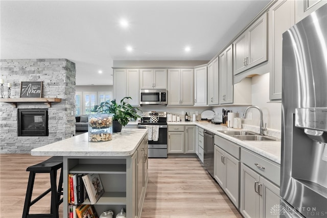 4978 Renaissance Park Dr, Middletown, OH 45005 - kitchen featuring appliances with stainless steel finishes, a sink, gray cabinetry, light wood-style floors, and a center island