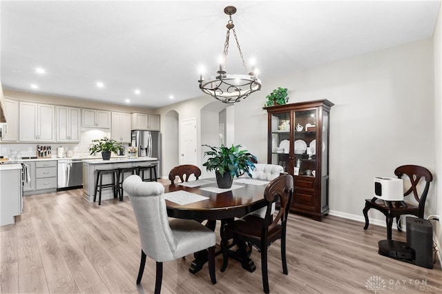 4978 Renaissance Park Dr, Middletown, OH 45005 - dining area featuring arched walkways, light wood-style floors, a chandelier, recessed lighting, and baseboards