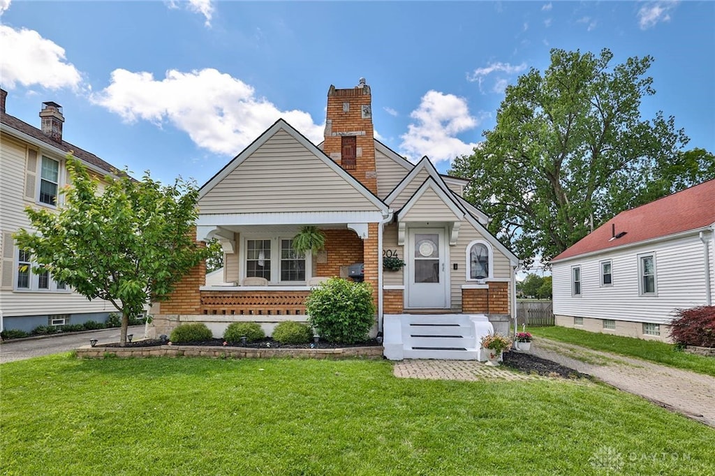 204 Rockhill Ave, Kettering, OH 45429 - view of front of house with a front lawn, brick siding, a chimney, and covered porch