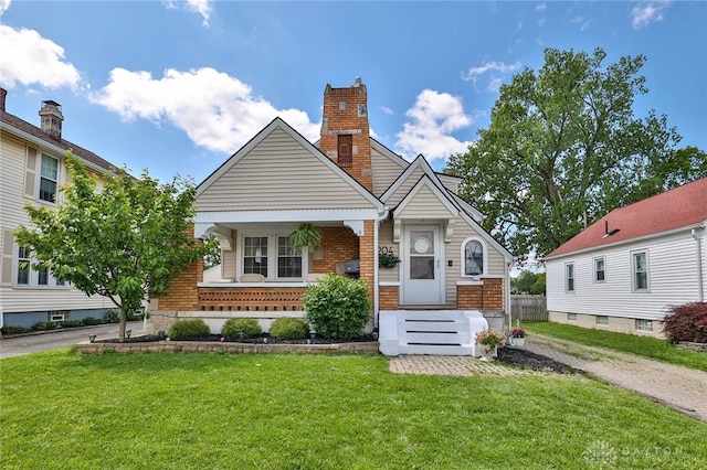 204 Rockhill Ave, Kettering, OH 45429 - view of front of house with a front lawn, brick siding, a chimney, and covered porch