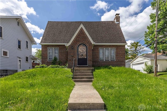 2312 Saint Charles Ave, Dayton, OH 45410 - tudor house with brick siding, a shingled roof, and a chimney
