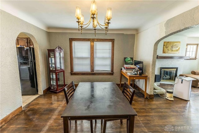 2312 Saint Charles Ave, Dayton, OH 45410 - dining space featuring a textured wall, arched walkways, wood finished floors, a glass covered fireplace, and a chandelier