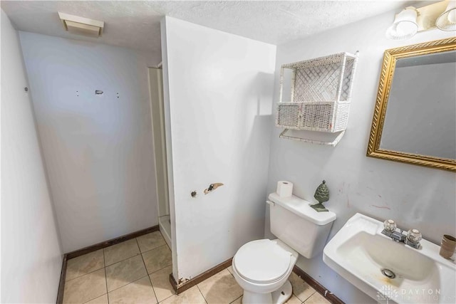2312 Saint Charles Ave, Dayton, OH 45410 - bathroom featuring toilet, a sink, tile patterned floors, baseboards, and a textured ceiling