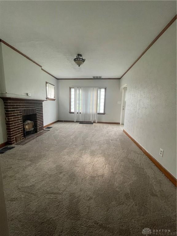 508 W Hillcrest Ave, Dayton, OH 45406 - unfurnished living room with baseboards, carpet flooring, and a brick fireplace