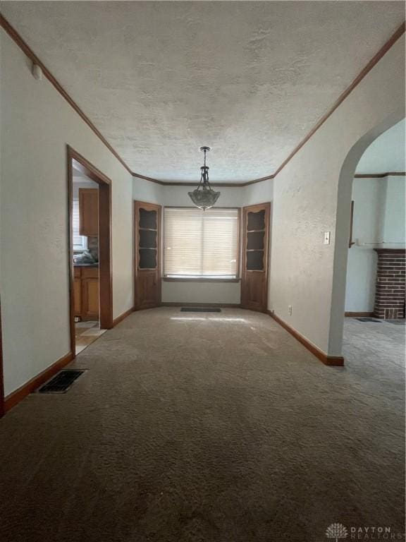 508 W Hillcrest Ave, Dayton, OH 45406 - unfurnished dining area featuring ornamental molding, arched walkways, light carpet, a textured ceiling, and baseboards