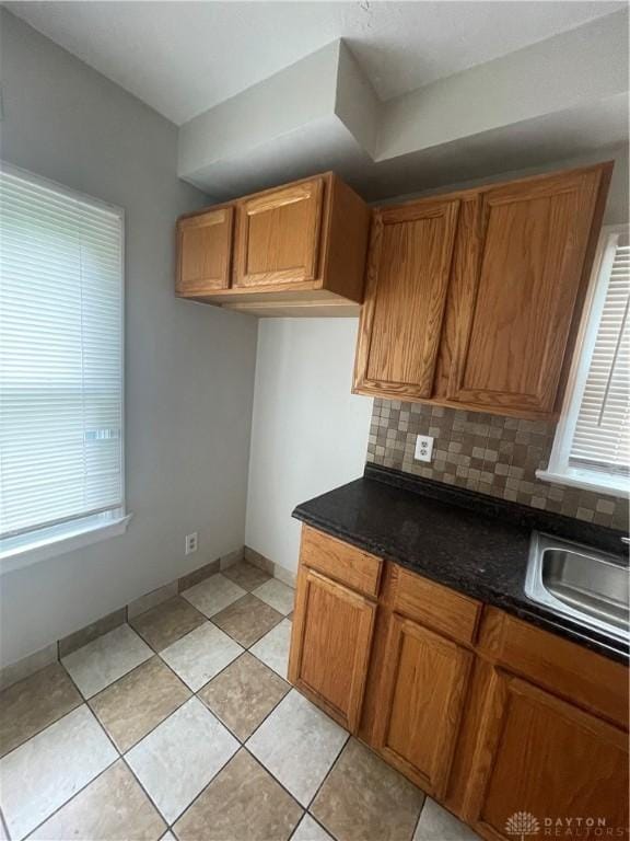 508 W Hillcrest Ave, Dayton, OH 45406 - kitchen featuring backsplash, brown cabinetry, and dark countertops