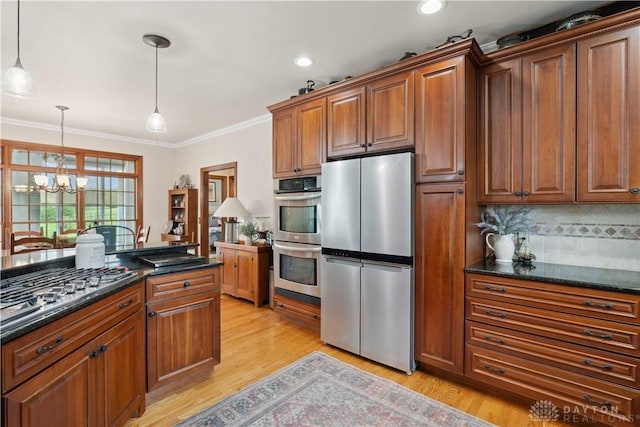 1134 N Webb Rd, Adams Twp, OH 45177 - kitchen with stainless steel appliances, light wood-type flooring, tasteful backsplash, decorative light fixtures, and a chandelier