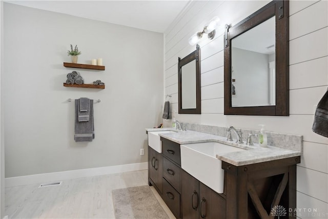 1134 N Webb Rd, Adams Twp, OH 45177 - bathroom featuring double vanity, baseboards, and wood finished floors