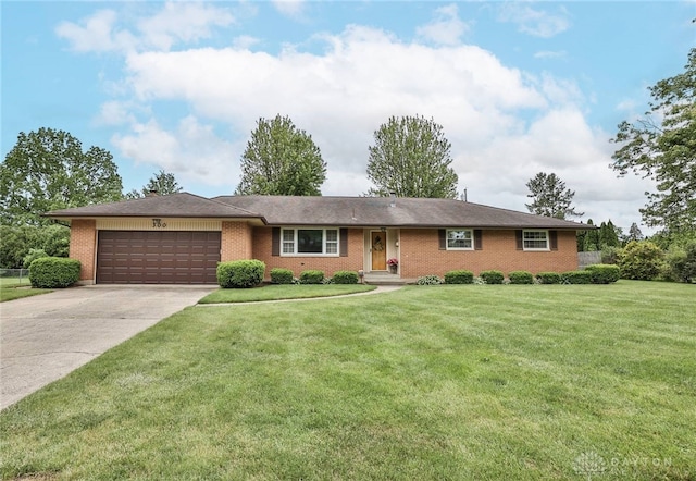 300 Magnolia Ave, Englewood, OH 45322 - ranch-style home with a garage, brick siding, concrete driveway, and a front lawn