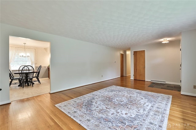 300 Magnolia Ave, Englewood, OH 45322 - living area with a baseboard radiator, a chandelier, baseboards, and wood finished floors