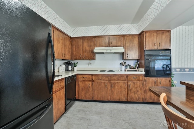 300 Magnolia Ave, Englewood, OH 45322 - kitchen featuring black appliances, under cabinet range hood, wallpapered walls, light countertops, and brown cabinetry