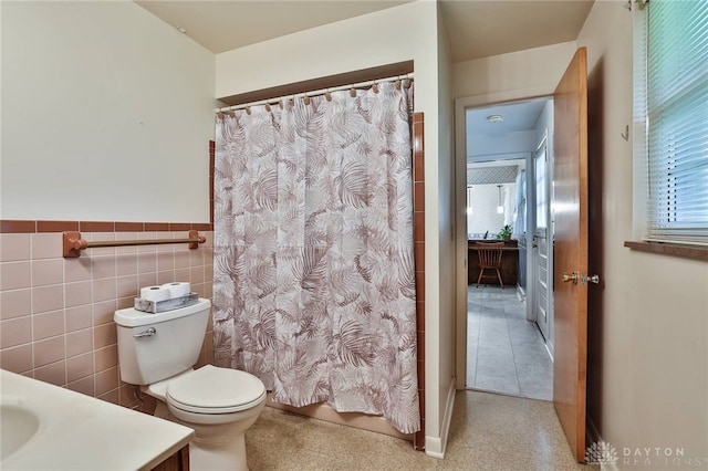 300 Magnolia Ave, Englewood, OH 45322 - full bath with vanity, toilet, a shower with shower curtain, a wainscoted wall, and tile walls