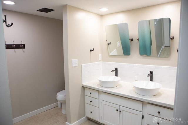 316 Honey Jane Dr, Beavercreek, OH 45434 - bathroom with double vanity, toilet, baseboards, tasteful backsplash, and wood finished floors