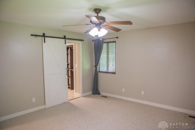 316 Honey Jane Dr, Beavercreek, OH 45434 - unfurnished bedroom with a barn door, carpet, baseboards, and a ceiling fan