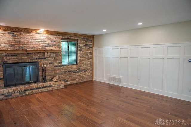 316 Honey Jane Dr, Beavercreek, OH 45434 - unfurnished living room with a decorative wall, wood finished floors, a brick fireplace, wainscoting, and brick wall