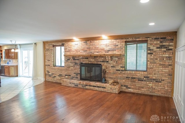 316 Honey Jane Dr, Beavercreek, OH 45434 - unfurnished living room featuring brick wall, wood finished floors, and a brick fireplace