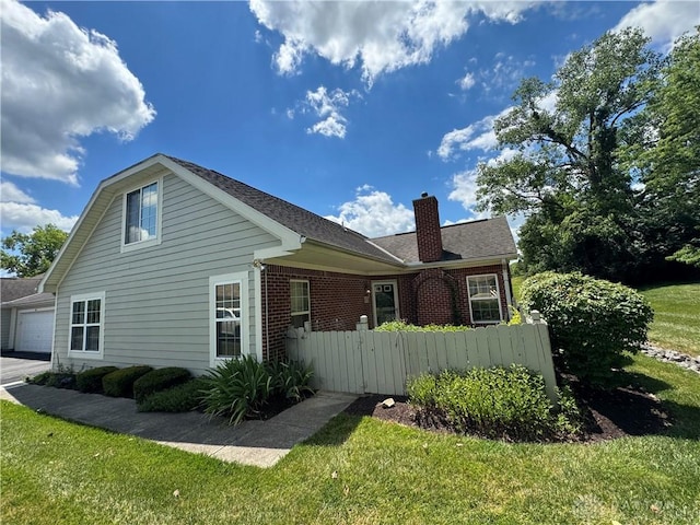 5023 Crescent Ridge Dr, Clayton, OH 45315 - view of side of property with a chimney, brick siding, and a garage