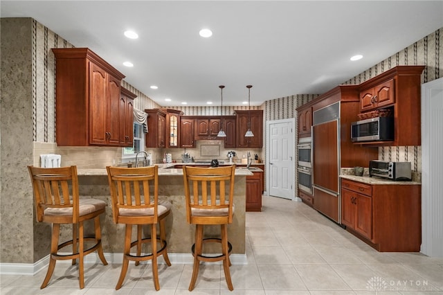 7607 Stone Ridge Dr, Springboro, OH 45066 - kitchen featuring stainless steel appliances, a peninsula, light countertops, recessed lighting, and glass insert cabinets