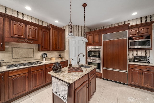 7607 Stone Ridge Dr, Springboro, OH 45066 - kitchen with built in appliances, a sink, decorative light fixtures, light tile patterned flooring, and a center island with sink